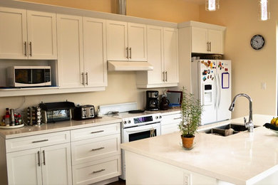 Example of a mid-sized trendy kitchen design in Toronto with shaker cabinets, white cabinets, quartz countertops and an island