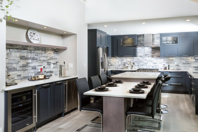 Inspiration for a medium tone wood floor eat-in kitchen remodel in Vancouver with shaker cabinets, black cabinets, quartz countertops and stone tile backsplash