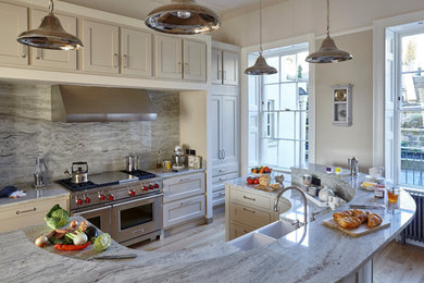 Inspiration for a large traditional galley kitchen/diner in Wiltshire with a belfast sink, shaker cabinets, grey cabinets, marble worktops, grey splashback, stone slab splashback, stainless steel appliances, medium hardwood flooring and an island.