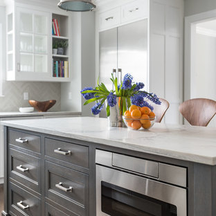 Mid-sized transitional open concept kitchen photos - Inspiration for a mid-sized transitional l-shaped dark wood floor open concept kitchen remodel in New York with an undermount sink, shaker cabinets, white cabinets, quartzite countertops, gray backsplash, ceramic backsplash, stainless steel appliances and an island