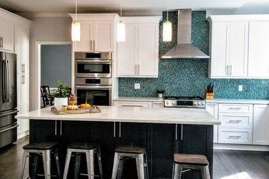 Mid-sized trendy u-shaped dark wood floor and brown floor eat-in kitchen photo in Miami with shaker cabinets, white cabinets, stainless steel appliances, an island, a farmhouse sink, marble countertops, blue backsplash, glass tile backsplash and white countertops