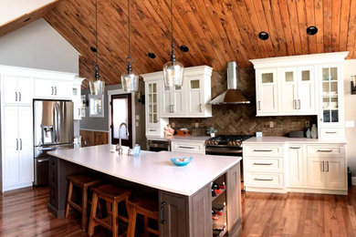 ボストンにある中くらいなビーチスタイルのおしゃれなキッチン (エプロンフロントシンク、落し込みパネル扉のキャビネット、白いキャビネット、珪岩カウンター、茶色いキッチンパネル、レンガのキッチンパネル、シルバーの調理設備、濃色無垢フローリング、茶色い床、白いキッチンカウンター) の写真