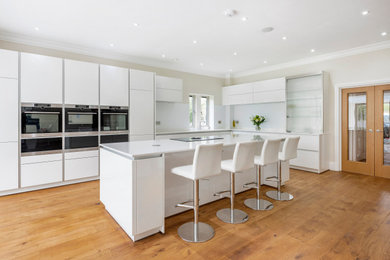 Large modern kitchen in Wiltshire with an island and white worktops.