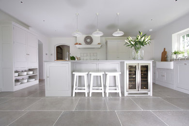 Inspiration for a large traditional open plan kitchen in Surrey with shaker cabinets, white cabinets, granite worktops, white splashback, an island and grey floors.