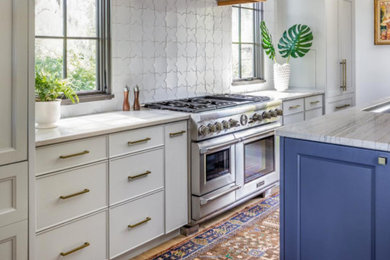 Tuscan medium tone wood floor kitchen photo in San Francisco with white cabinets, marble countertops, white backsplash, ceramic backsplash and an island