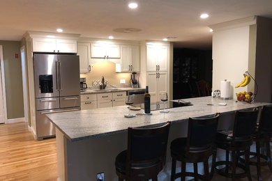 Inspiration for a mid-sized timeless single-wall light wood floor and beige floor open concept kitchen remodel in Boston with a double-bowl sink, shaker cabinets, white cabinets, quartzite countertops, stainless steel appliances, a peninsula and gray countertops