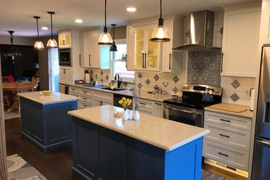 Inspiration for a mid-sized transitional single-wall dark wood floor and brown floor eat-in kitchen remodel in Cleveland with an undermount sink, shaker cabinets, white cabinets, blue backsplash, ceramic backsplash, stainless steel appliances, two islands and white countertops
