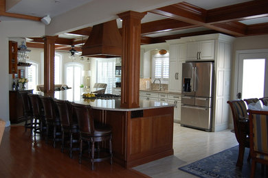 Mid-sized elegant single-wall porcelain tile and beige floor open concept kitchen photo in New Orleans with an undermount sink, raised-panel cabinets, white cabinets, quartz countertops, multicolored backsplash, mosaic tile backsplash, stainless steel appliances and an island