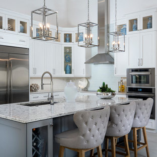 Transitional kitchen pictures - Transitional l-shaped gray floor kitchen photo in Miami with an undermount sink, shaker cabinets, white cabinets, gray backsplash, stainless steel appliances, an island and gray countertops