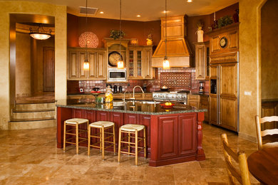 Tuscan l-shaped kitchen photo in Phoenix with raised-panel cabinets, medium tone wood cabinets, brown backsplash and paneled appliances