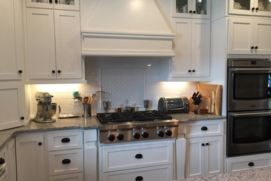 Foto på ett rustikt kök och matrum, med en undermonterad diskho, skåp i shakerstil, vita skåp, granitbänkskiva, vitt stänkskydd, stänkskydd i keramik, rostfria vitvaror, mörkt trägolv och en köksö