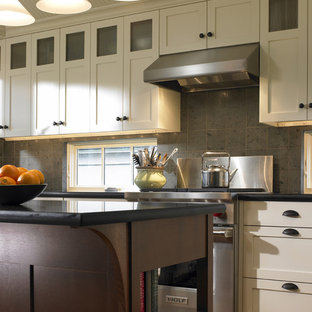 Elegant kitchen photo in Seattle with stainless steel appliances, shaker cabinets and gray backsplash