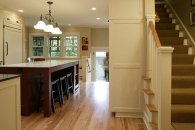 Example of a mid-sized classic l-shaped light wood floor eat-in kitchen design in Portland with shaker cabinets, white cabinets, granite countertops, an island, an undermount sink, white backsplash, subway tile backsplash and paneled appliances