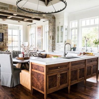Inspiration for a large country dark wood floor eat-in kitchen remodel in Salt Lake City with a farmhouse sink, recessed-panel cabinets, medium tone wood cabinets, marble countertops, white backsplash, paneled appliances and an island