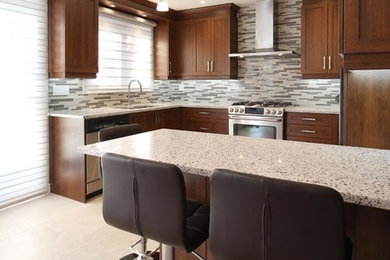 Mid-sized elegant u-shaped porcelain tile and gray floor eat-in kitchen photo in Montreal with an undermount sink, shaker cabinets, dark wood cabinets, quartz countertops, gray backsplash, ceramic backsplash, stainless steel appliances and a peninsula