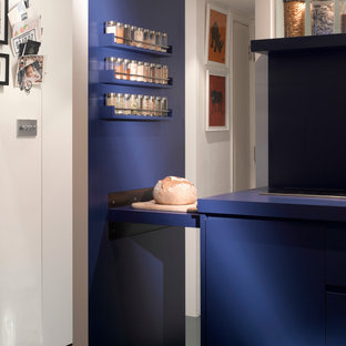 Inspiration for a small contemporary open plan kitchen in London with a drop-in sink, flat-panel cabinets, blue cabinets, stainless steel appliances and ceramic floors.