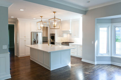 Example of a large trendy u-shaped dark wood floor and brown floor eat-in kitchen design in Kansas City with recessed-panel cabinets, white cabinets, an island, quartzite countertops, gray backsplash, marble backsplash, stainless steel appliances and an undermount sink