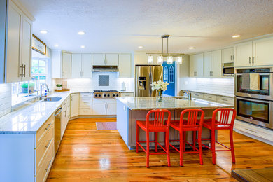 Inspiration for a large u-shaped light wood floor and multicolored floor eat-in kitchen remodel in Portland with a double-bowl sink, flat-panel cabinets, white cabinets, white backsplash, subway tile backsplash, stainless steel appliances, an island and multicolored countertops