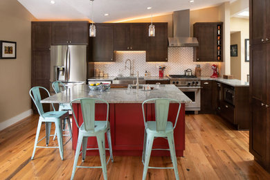 Inspiration for a mid-sized transitional l-shaped medium tone wood floor and brown floor eat-in kitchen remodel in Denver with a farmhouse sink, shaker cabinets, medium tone wood cabinets, granite countertops, white backsplash, ceramic backsplash, stainless steel appliances, an island and gray countertops