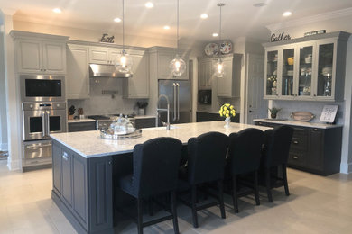 Inspiration for a transitional porcelain tile and beige floor kitchen remodel in Other with a single-bowl sink, raised-panel cabinets, gray cabinets, quartz countertops, gray backsplash, ceramic backsplash and stainless steel appliances