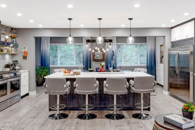 Example of a large transitional laminate floor and multicolored floor eat-in kitchen design in Vancouver with flat-panel cabinets, white cabinets, quartzite countertops, multicolored backsplash, cement tile backsplash, stainless steel appliances, an island and white countertops