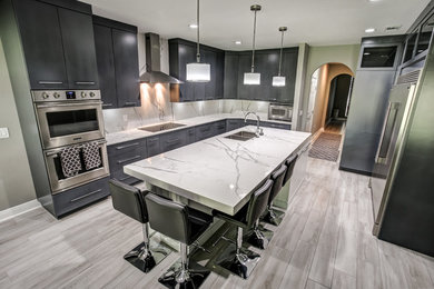 Mid-sized minimalist l-shaped porcelain tile and gray floor enclosed kitchen photo in Other with an undermount sink, flat-panel cabinets, gray cabinets, quartz countertops, multicolored backsplash, stone slab backsplash, stainless steel appliances and an island