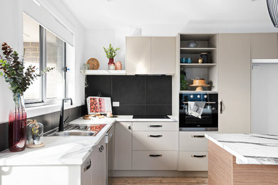 Small contemporary galley open plan kitchen in Other with a single-bowl sink, recessed-panel cabinets, grey cabinets, laminate countertops, black splashback, ceramic splashback, stainless steel appliances, vinyl flooring, an island, brown floors and multicoloured worktops.
