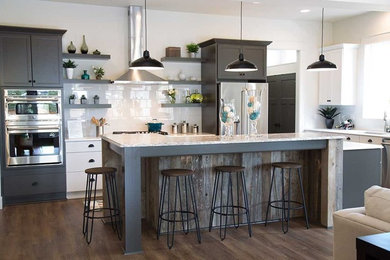 Inspiration for a large contemporary l-shaped dark wood floor and brown floor eat-in kitchen remodel with an undermount sink, shaker cabinets, brown cabinets, granite countertops, white backsplash, subway tile backsplash, stainless steel appliances and an island