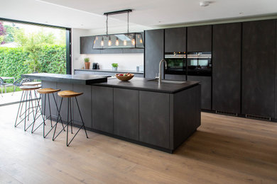 This is an example of an expansive contemporary open plan kitchen in London with an island.