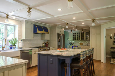 Example of a large classic l-shaped medium tone wood floor and brown floor eat-in kitchen design in Bridgeport with a farmhouse sink, shaker cabinets, beige cabinets, granite countertops, white backsplash, ceramic backsplash, stainless steel appliances and an island