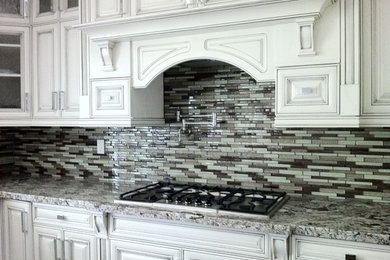 Inspiration for a large timeless u-shaped open concept kitchen remodel in Vancouver with an undermount sink, beaded inset cabinets, white cabinets, granite countertops, multicolored backsplash, mosaic tile backsplash, stainless steel appliances and an island