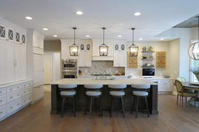 Large transitional l-shaped medium tone wood floor, brown floor and wood ceiling open concept kitchen photo in Detroit with an undermount sink, flat-panel cabinets, white cabinets, quartzite countertops, gray backsplash, stone tile backsplash, stainless steel appliances, an island and gray countertops