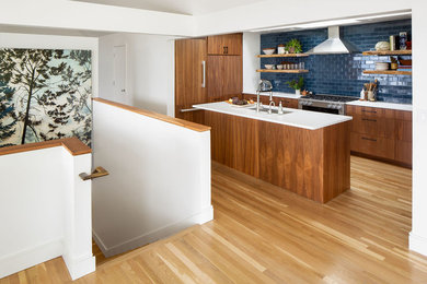 Large transitional u-shaped medium tone wood floor and brown floor open concept kitchen photo in Seattle with an undermount sink, flat-panel cabinets, medium tone wood cabinets, quartz countertops, blue backsplash, ceramic backsplash, stainless steel appliances, an island and white countertops