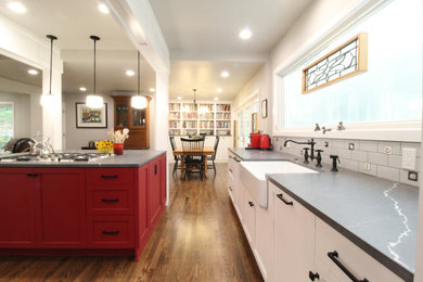Mid-sized country galley medium tone wood floor, brown floor and exposed beam open concept kitchen photo in Seattle with a farmhouse sink, shaker cabinets, red cabinets, quartz countertops, gray backsplash, cement tile backsplash, paneled appliances, two islands and gray countertops