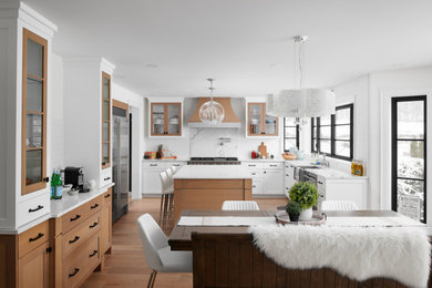 Inspiration for a large transitional u-shaped eat-in kitchen remodel in Toronto with a farmhouse sink, shaker cabinets, light wood cabinets, quartzite countertops, white backsplash, ceramic backsplash, stainless steel appliances, an island and white countertops