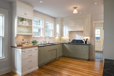 Inspiration for a mid-sized timeless u-shaped medium tone wood floor eat-in kitchen remodel in Other with an undermount sink, shaker cabinets, white cabinets, soapstone countertops, subway tile backsplash, paneled appliances, no island and white backsplash