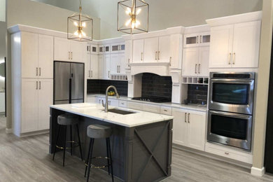 Inspiration for a timeless eat-in kitchen remodel in Boston with an undermount sink, shaker cabinets, white cabinets, quartzite countertops, an island and white countertops