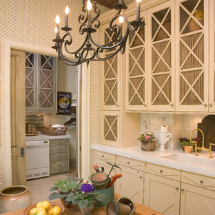Photo of a traditional kitchen in Other with glass-front cabinets and beige cabinets.