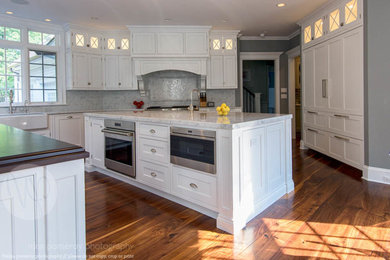 Inspiration for a huge timeless kitchen remodel in San Francisco with shaker cabinets, white cabinets, marble countertops, gray backsplash, subway tile backsplash, stainless steel appliances and two islands