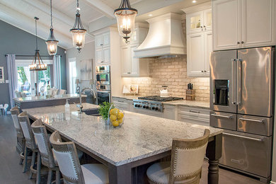 Large transitional l-shaped eat-in kitchen photo in Other with a double-bowl sink, shaker cabinets, white cabinets, beige backsplash, stainless steel appliances and an island