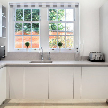 Light grey handle-less kitchen with built in sink & hidden appliances