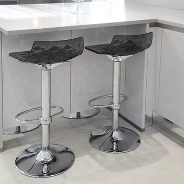 Light grey handle-less kitchen with modern bar stools