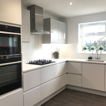 Light grey matt painted handleless kitchen with quartz worktop