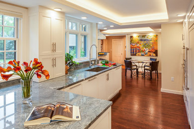 Open concept kitchen - large transitional galley medium tone wood floor open concept kitchen idea in Boston with an undermount sink, shaker cabinets, white cabinets, granite countertops, multicolored backsplash, stone slab backsplash, stainless steel appliances and a peninsula