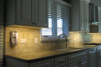 Example of a l-shaped eat-in kitchen design in Chicago with a drop-in sink, gray cabinets, beige backsplash and ceramic backsplash
