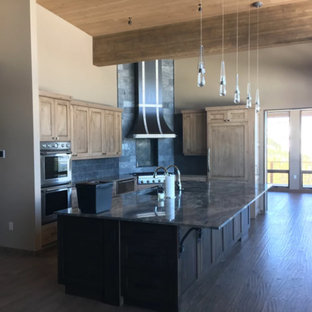 Photo of a mid-sized country single-wall open plan kitchen in Other with an undermount sink, shaker cabinets, medium wood cabinets, granite benchtops, grey splashback, slate splashback, stainless steel appliances, dark hardwood floors, with island and brown floor.