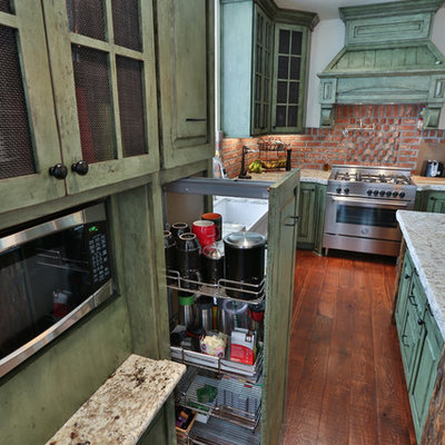 Example of a mid-sized eclectic l-shaped medium tone wood floor eat-in kitchen design in Portland with a farmhouse sink, raised-panel cabinets, green cabinets, granite countertops, red backsplash, stainless steel appliances and an island
