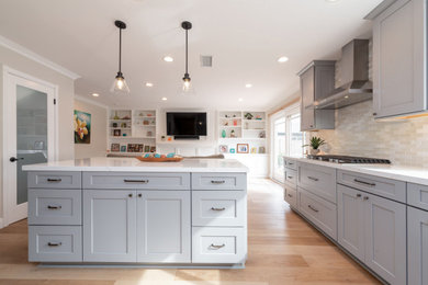 Example of a mid-sized transitional kitchen design in Orange County with shaker cabinets, gray cabinets, quartz countertops, white backsplash, mosaic tile backsplash, stainless steel appliances, an island and white countertops