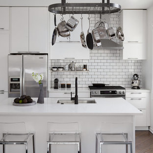 Small contemporary kitchen remodeling - Inspiration for a small contemporary galley dark wood floor and brown floor kitchen remodel in Chicago with an undermount sink, flat-panel cabinets, white cabinets, quartz countertops, white backsplash, ceramic backsplash, stainless steel appliances, an island and white countertops