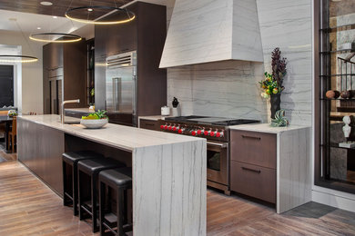 Example of a large trendy galley dark wood floor eat-in kitchen design in Chicago with an undermount sink, flat-panel cabinets, dark wood cabinets, gray backsplash, stone slab backsplash, stainless steel appliances and an island